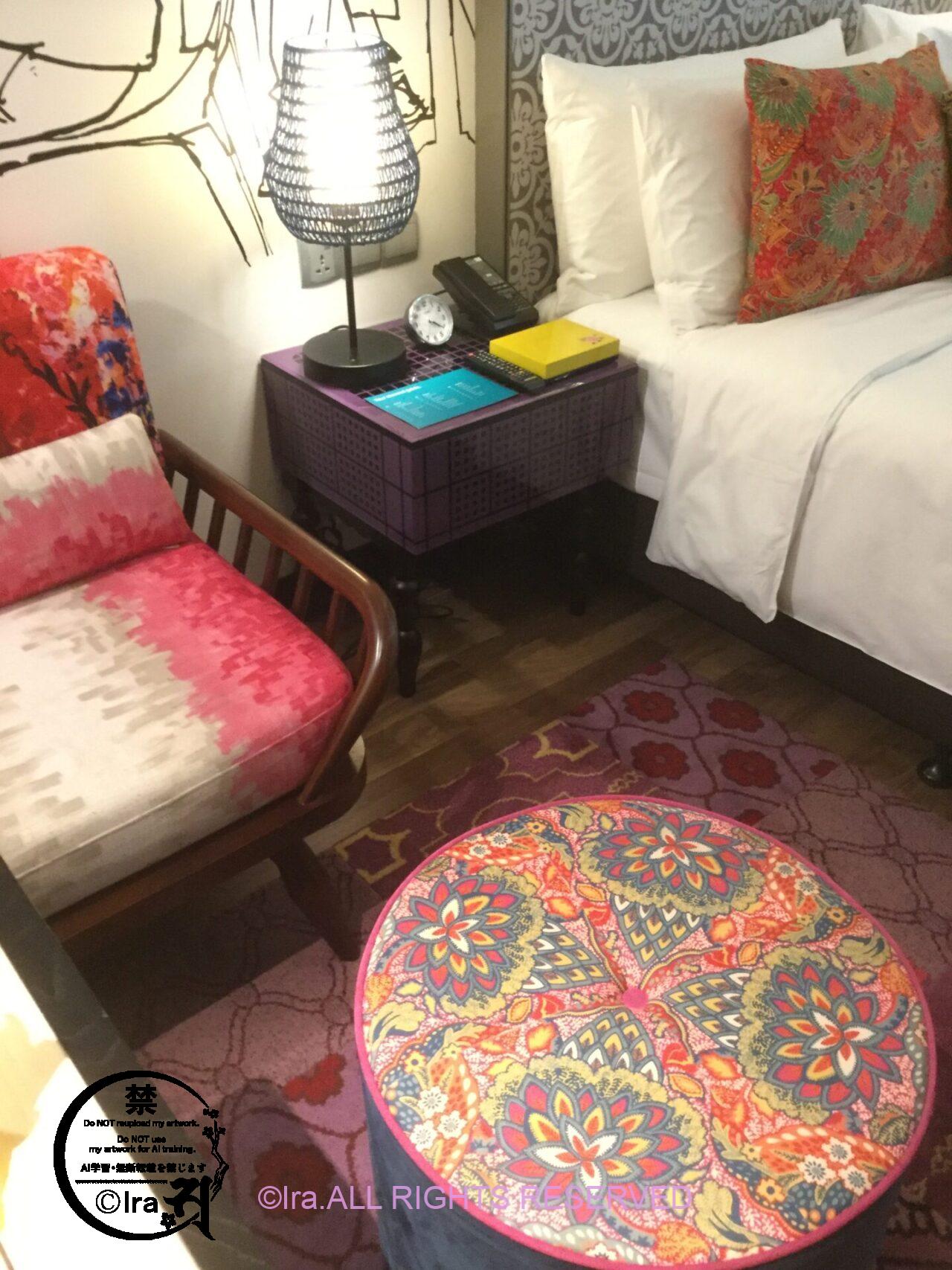 シンガポールで人気のプラナカンホテルHOTEL INDIGO SINGAPORE KATONGの部屋の椅子とベッドとミニテーブル